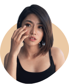 woman with short hair touching her eye
